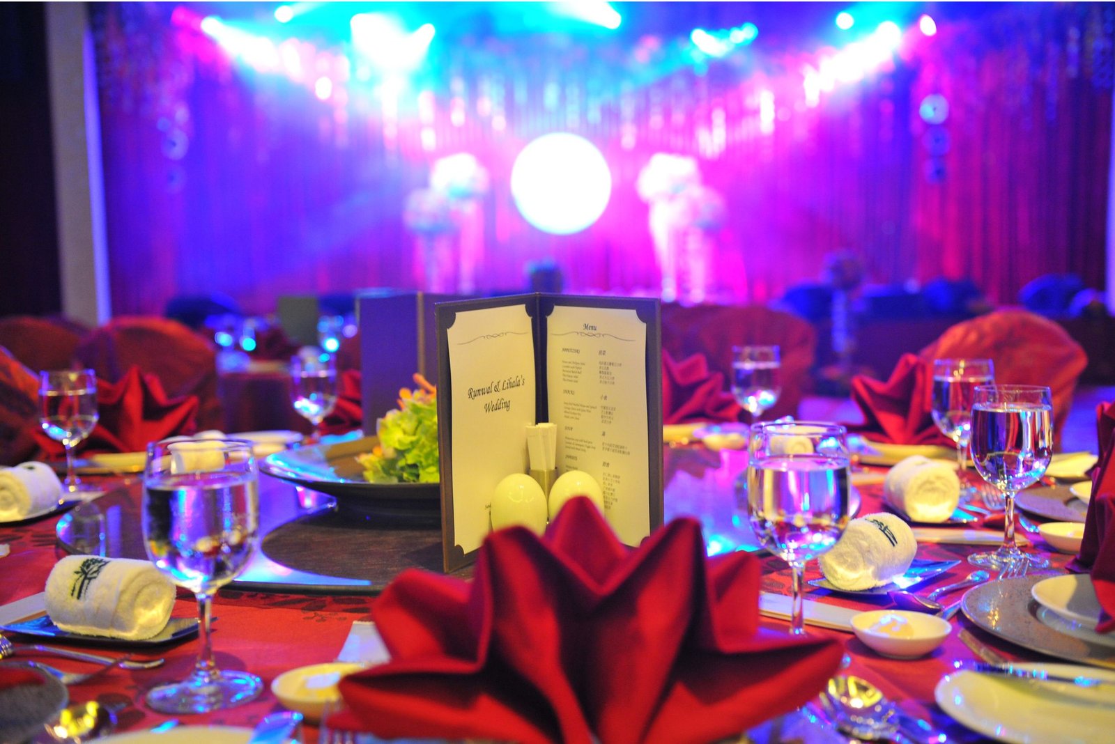 Balloon arch in orange, black, and white colors framing an ITT logo board lit with warm lights